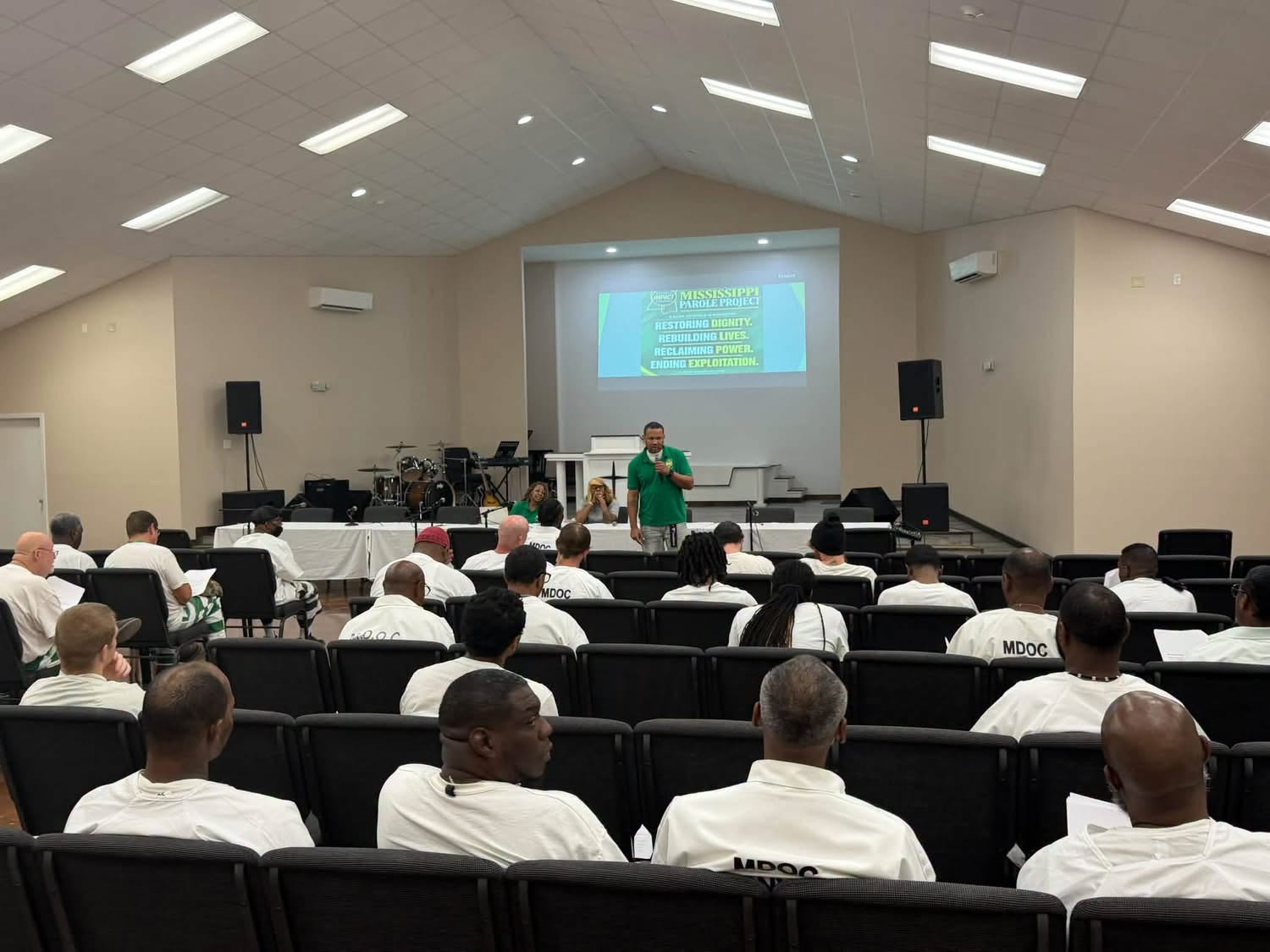Room of participants facing a screen reading Mississippi Parole Project: Restoring Dignity, Rebuilding Lives, Reclaiming Power, Ending Exploitation